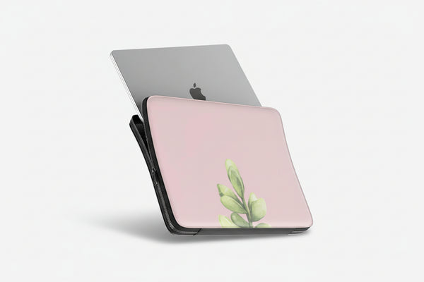 Pink laptop case with green plant design and Apple logo on a white background